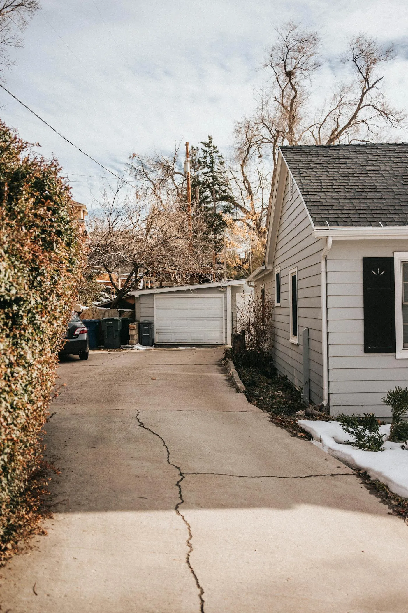 Cracked and crumbling old suburban concrete driveway in need of replacement