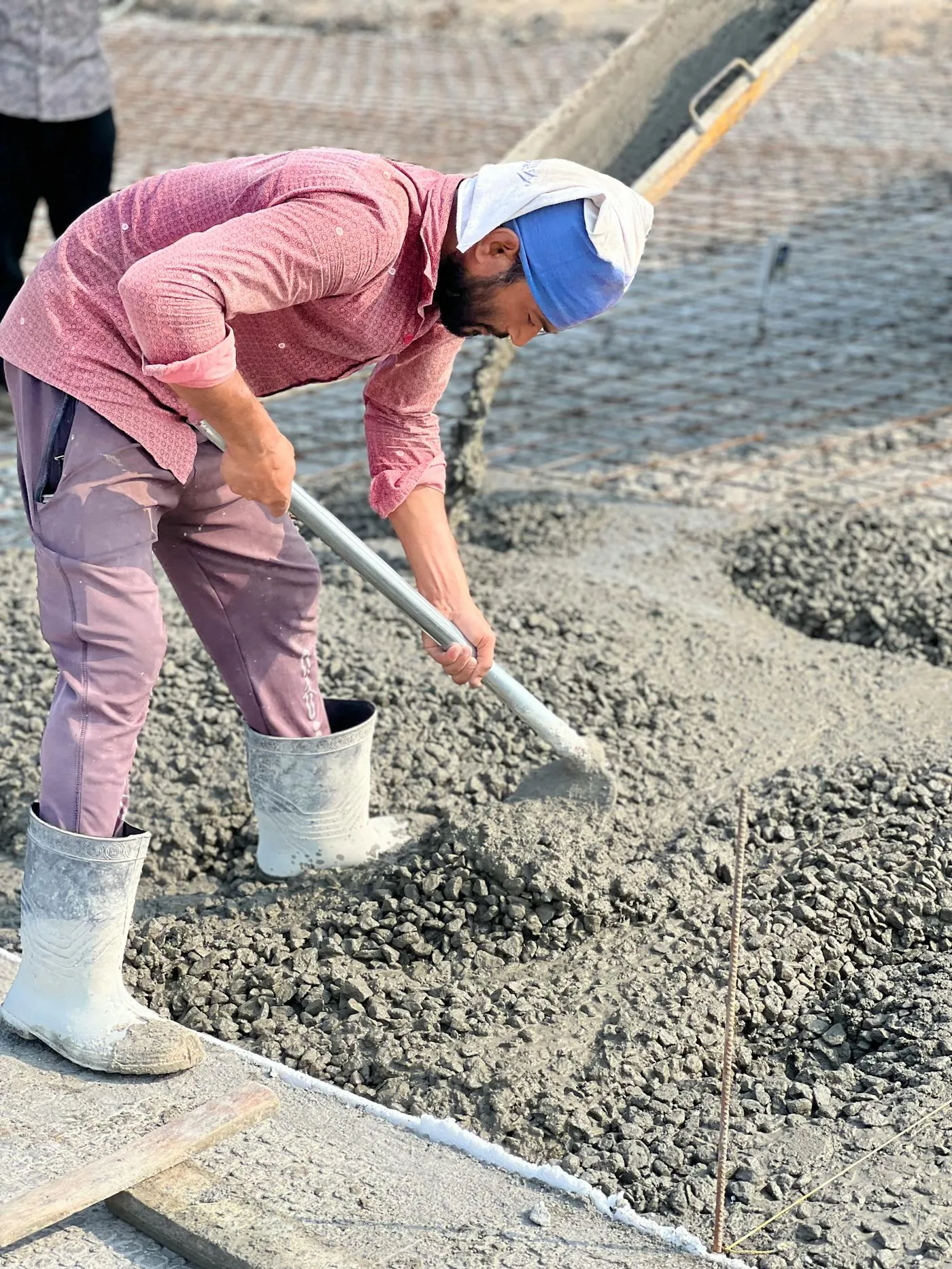 Concreting crew spreading and levelling freshly poured concrete on site