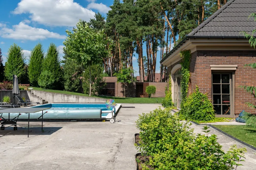 Concrete pool surround beside a backyard swimming pool